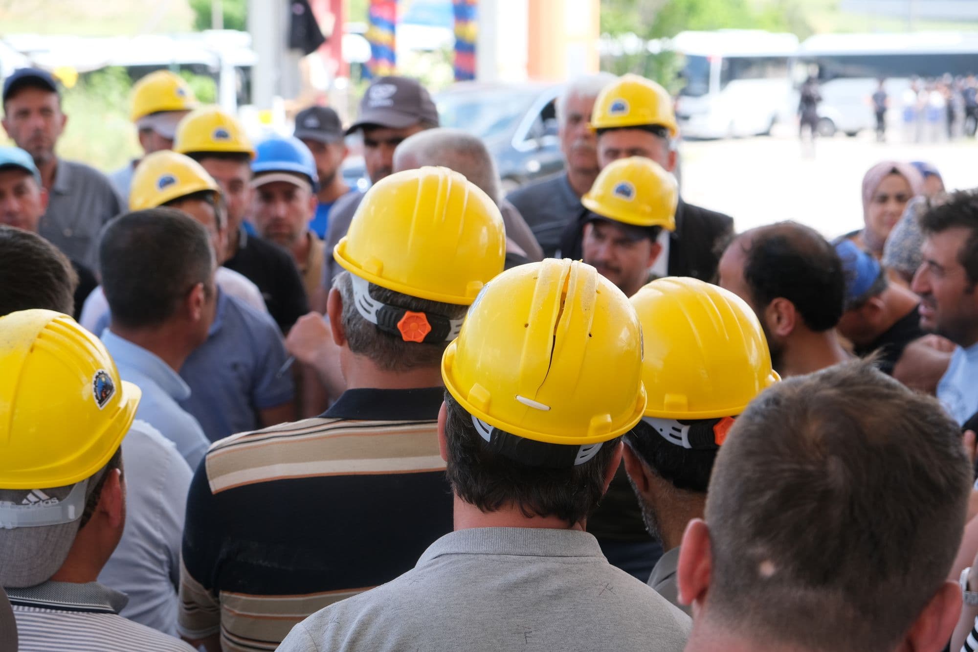 Large team of UK construction workers in yellow hard hats on site, the people we help get CSCS cards