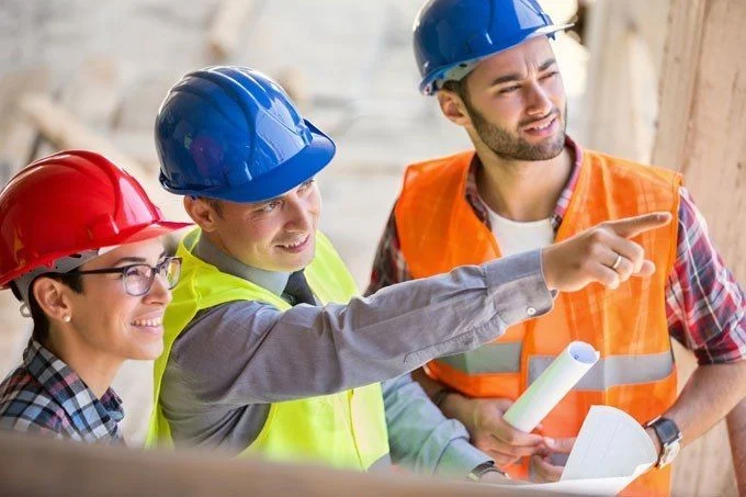 Construction workers in safety helmets discussing work plans on a building site